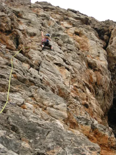 Climber scalling up a 30 meter route in Sagres