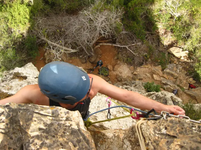 Climber clipping an anchor at the Lagos climbing site