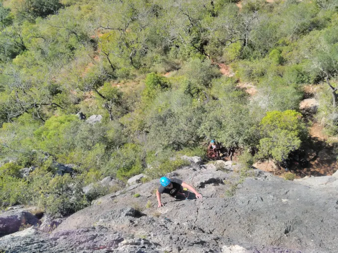 Climber halfway through a lead in Rocha da Pena
