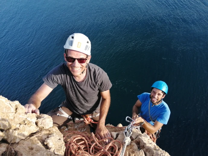 Climbers preparing anchors during a rope access course.