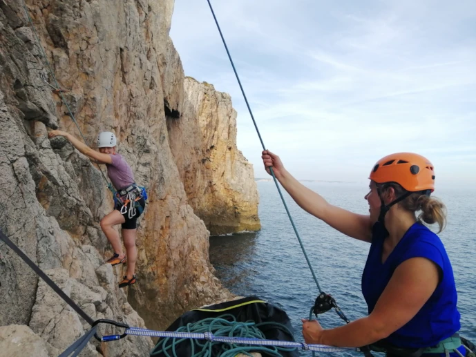 Climbers preparing anchors during a rope access course.