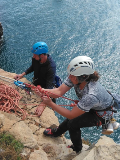 Climbers practicing belaying from the top during a rope access course in Sagres.