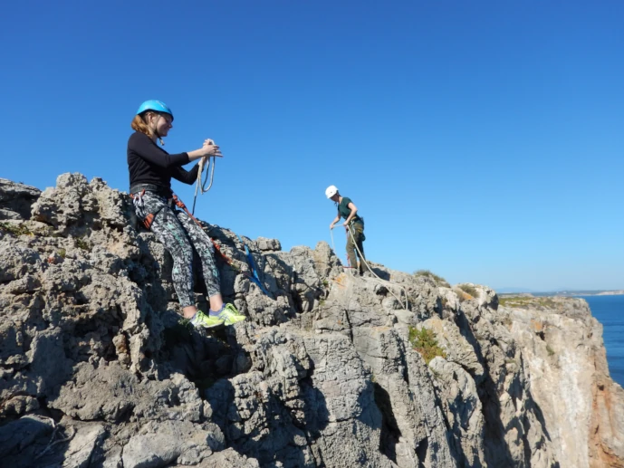 Climbers preparing anchors during a rope access course.