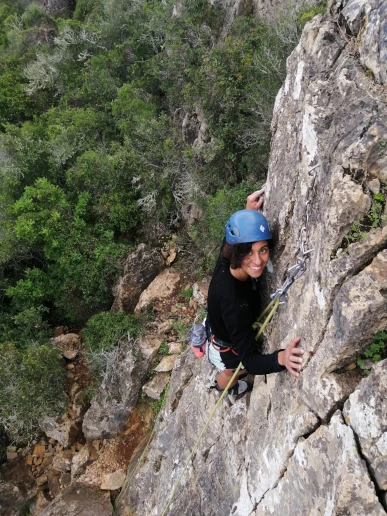 Climber reaching the top of a route at the Lagos climbing area
