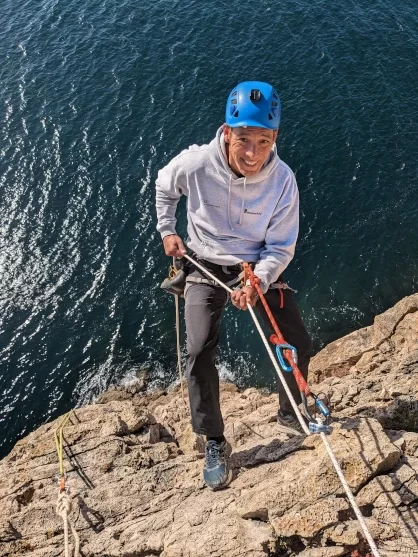 Climber abseiling/rappeling down to the ocean at Sagres during a Rope Access course in Portuga
